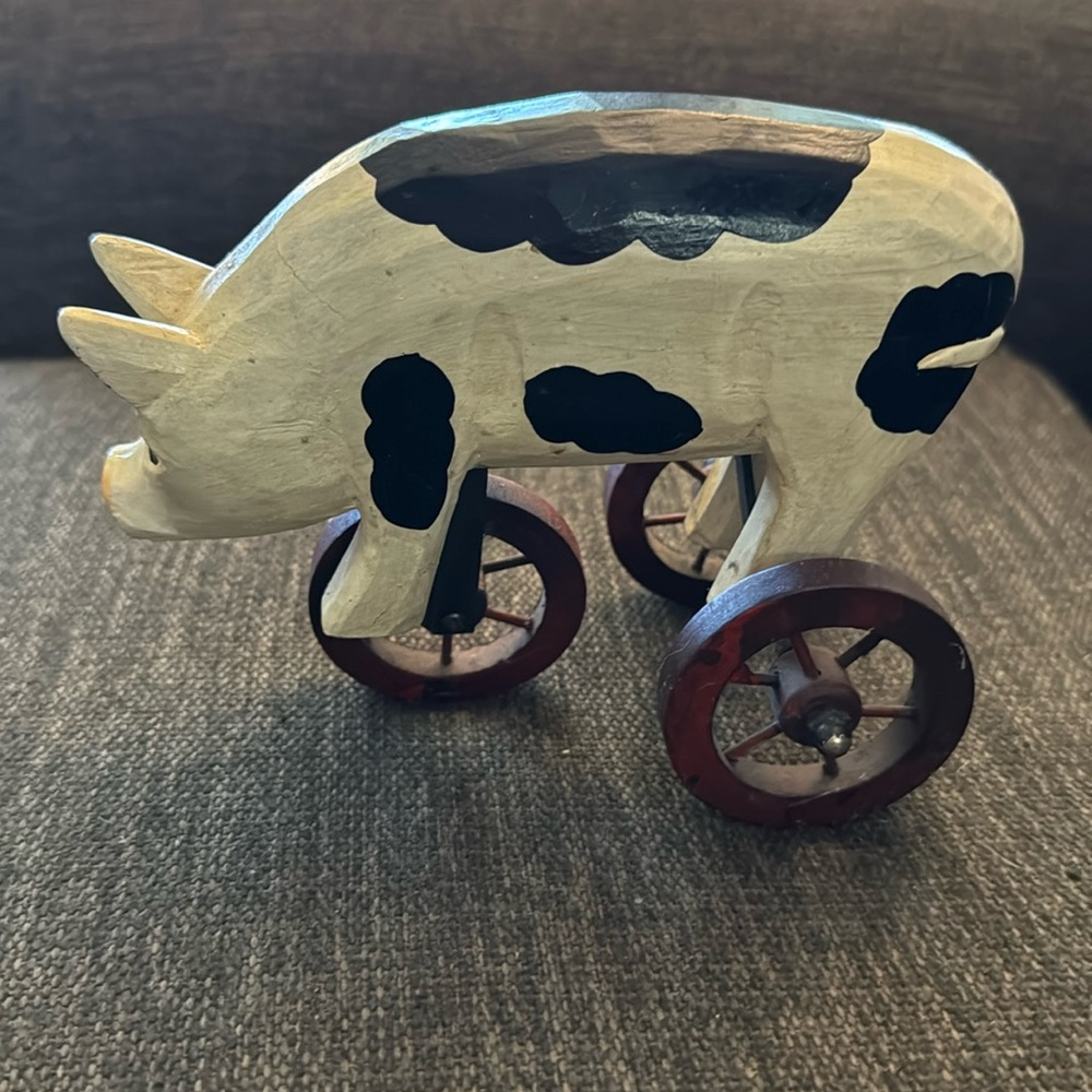 Vintage wooden pig on tricycle wheels